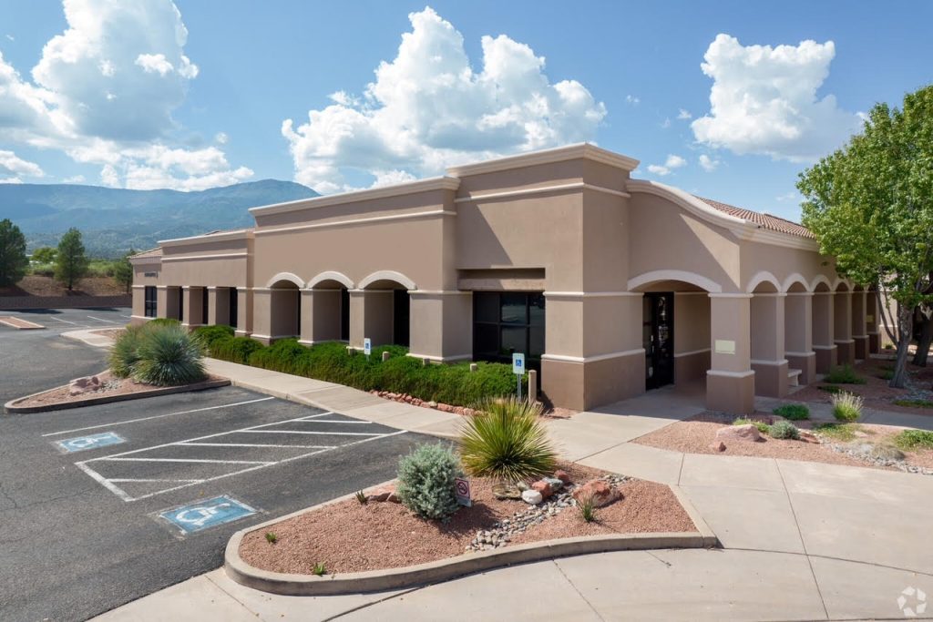 Optima Medical primary care clinic in Cottonwood, Arizona, featuring a modern desert-style building with patient parking and mountain views in the background.