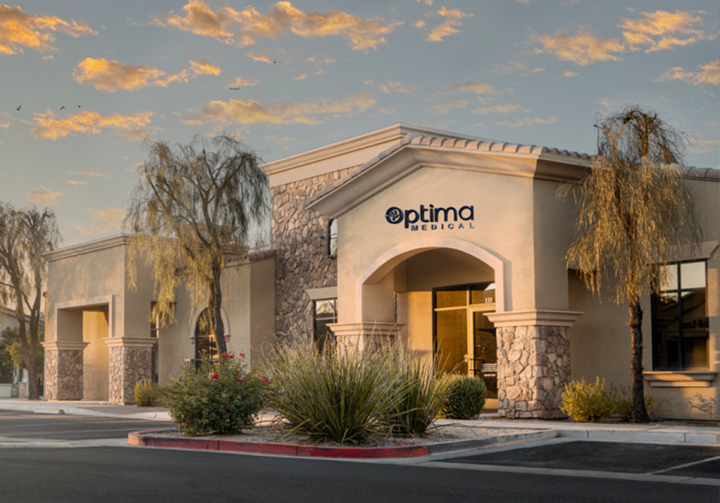 Exterior view of Optima Medical primary care clinic at 21321 East Ocotillo Road, Suite 133, Queen Creek, Arizona, featuring modern stone and stucco design.