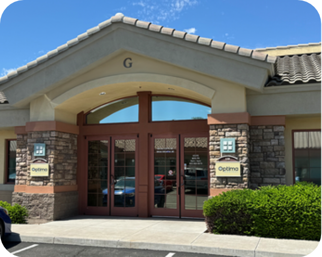 Front entrance of Optima Medical Arrowhead clinic in Glendale, Arizona, with stone pillars and glass doors.