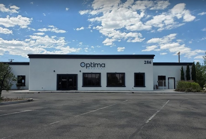 Exterior view of Optima Medical primary care clinic at 286 South Lenzner Avenue in Sierra Vista, Arizona, showing modern beige building with black trim and clear blue sky.